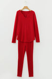 Red ribbed long-sleeve top and pants set on a hanger against a white background