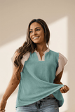 Woman wearing a teal sleeveless top with a beige background