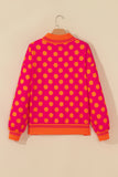Rose polka dot sweatshirt with orange striped cuffs and hem on a hanger
