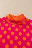 Close-up of orange striped mock neck on rose polka dot sweatshirt