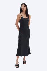 Woman wearing a black slip dress on a white background