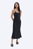 Woman wearing a black slip dress on a white background