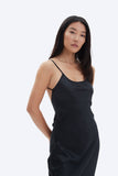 Woman wearing a black slip dress against a white background