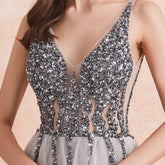 Close-up of a sparkling silver dress with a V-neckline on a soft pink background