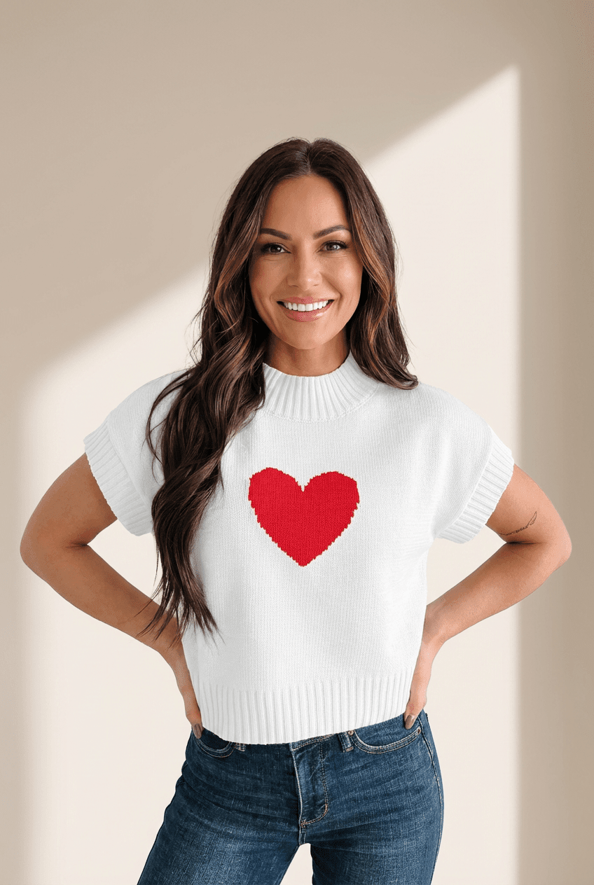 Woman wearing a white sweater with a red heart design on a beige background