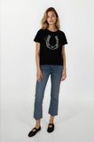 Woman wearing a black t-shirt with a horseshoe design and blue jeans on a white background