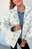 Woman in sky blue floral quilted puffer jacket with striped tee and black pants