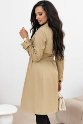 Woman wearing a beige trench coat with a white background