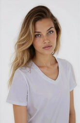Woman wearing a white t-shirt against a plain background