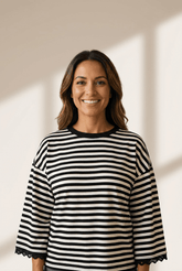 Woman wearing a black and white striped shirt against a neutral background
