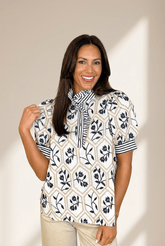 Woman wearing a patterned blouse against a plain background