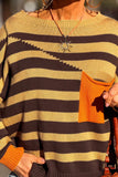 Close-up of a striped knit sweater with orange pocket and cuffs, warm sunlight, jewelry visible.