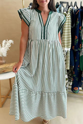 Woman wearing a green and white striped dress in a clothing store.