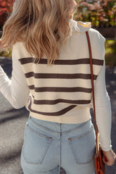 Woman from behind in a cream and dark brown striped sweater vest, white top, jeans, and brown bag.
