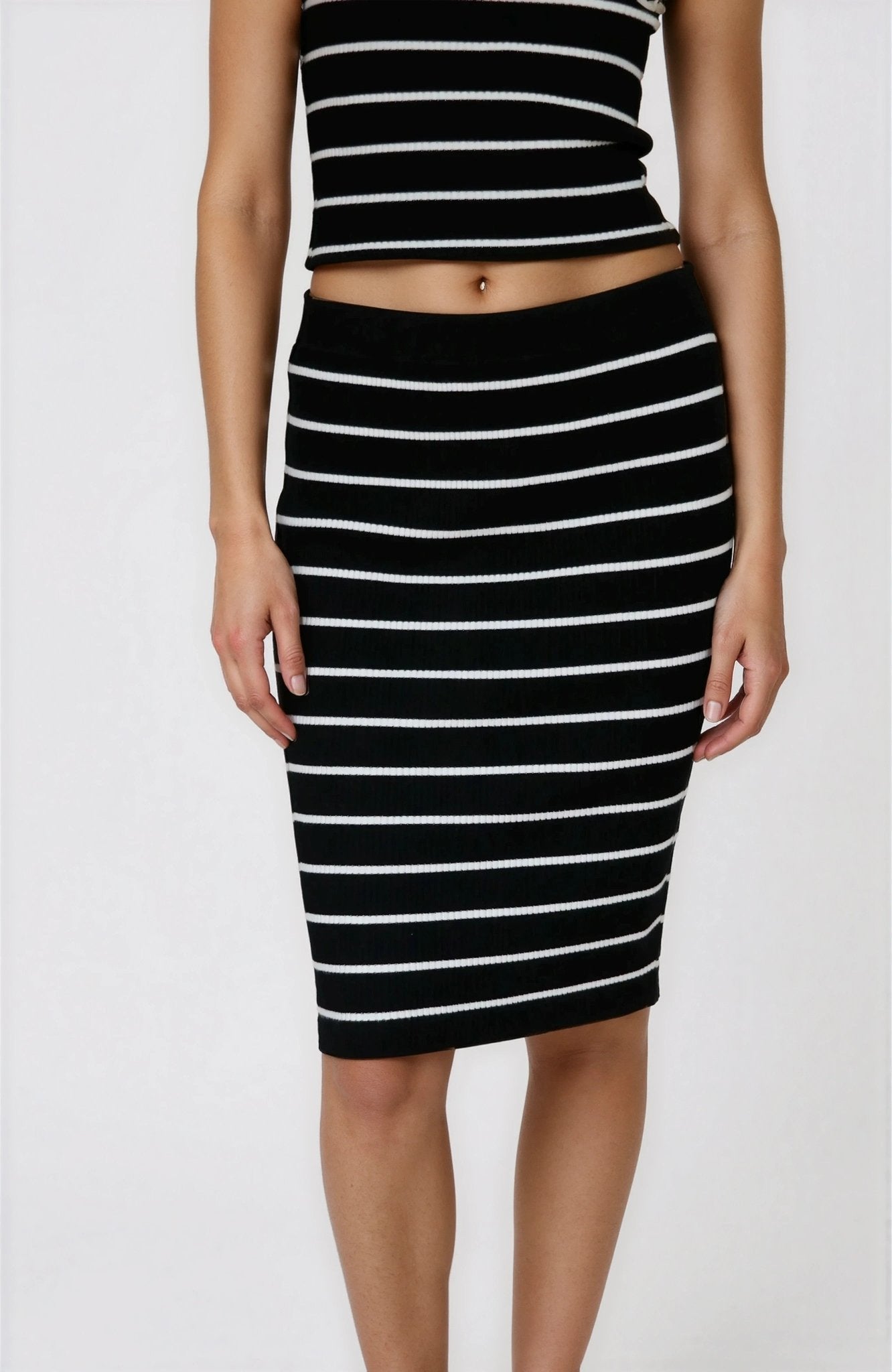 Person wearing a black and white striped top and skirt on a white background