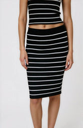 Person wearing a black and white striped top and skirt on a white background