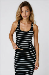 Woman wearing a black and white striped dress on a plain background