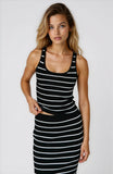 Woman wearing a black and white striped dress on a plain background