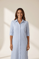 Woman wearing a blue and white striped dress against a beige background