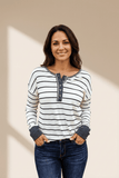 Woman wearing a black and white striped shirt with a bow detail on a beige background