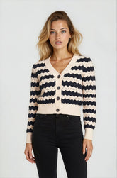 Woman wearing a black and white striped cardigan on a plain background