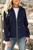 Woman wearing a navy blue jacket with white buttons, standing outdoors.