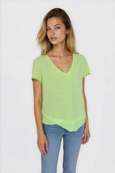 Woman wearing a light green blouse with lace trim on a white background