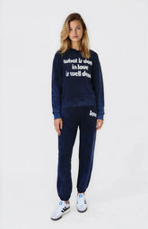 Woman wearing a navy tracksuit with text on a white background