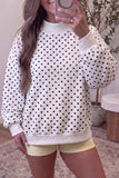 White polka dot mock neck sweatshirt with black dots, front view on model