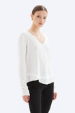 Woman wearing a white blouse and black pants on a white background