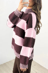 Woman wearing fuzzy knit mock-neck sweater with dark plum and light pink stripes, paired with brown pants.