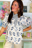 Woman wearing a patterned blouse in a home office setting
