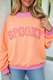 Women's plus size orange SPOOKY polka dot Halloween sweatshirt with pink trim, front view