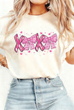 Person wearing a white t-shirt with pink ribbon design and text.