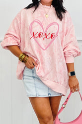 Person wearing a pink tie-dye sweatshirt with 'xoxo' design, denim shorts, and holding a pink handbag.