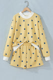 Yellow polka dot top and shorts set on hanger, front view