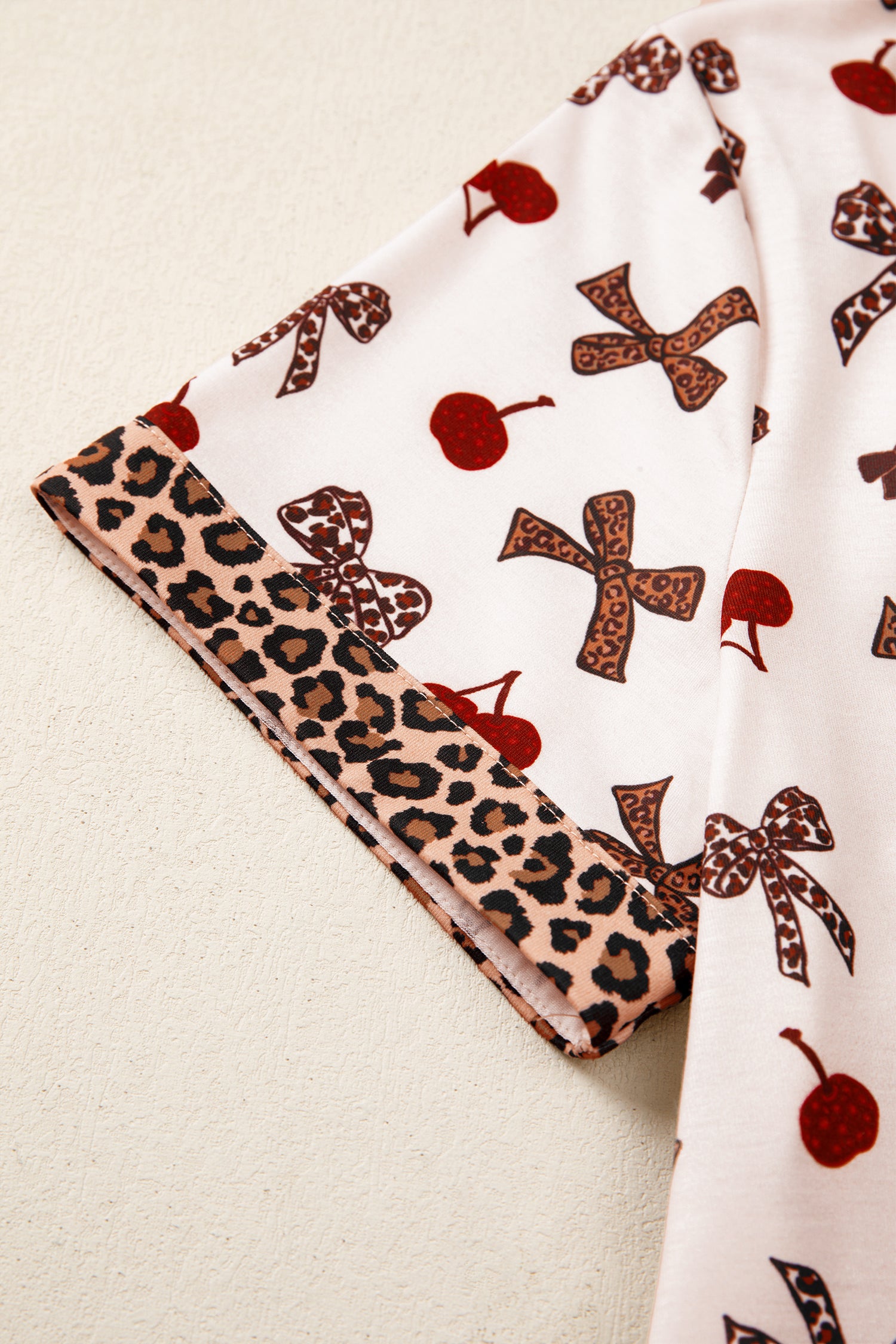 Fabric with leopard print border and patterned design on a beige background