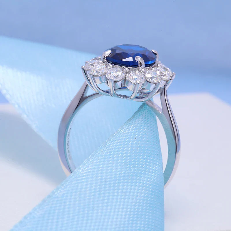 Silver ring with a blue gemstone and diamonds on a light blue background