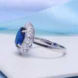 Silver ring with a blue gemstone on a light background