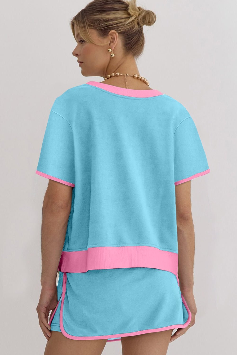 Woman wearing a blue and pink dress against a plain background