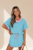 Woman wearing a blue and pink outfit with a beige background