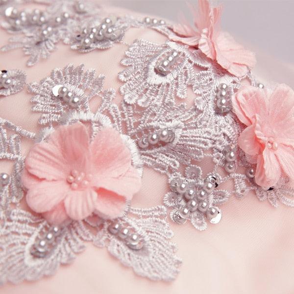Close-up of silver lace with pink flowers on a light background