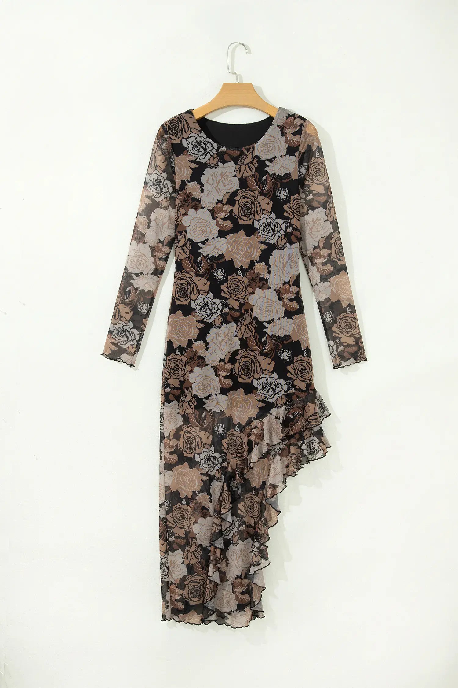 A long-sleeve midi dress with a sheer black mesh base and a brown, beige, and gray floral print, hanging on a wooden hanger against a plain white wall.