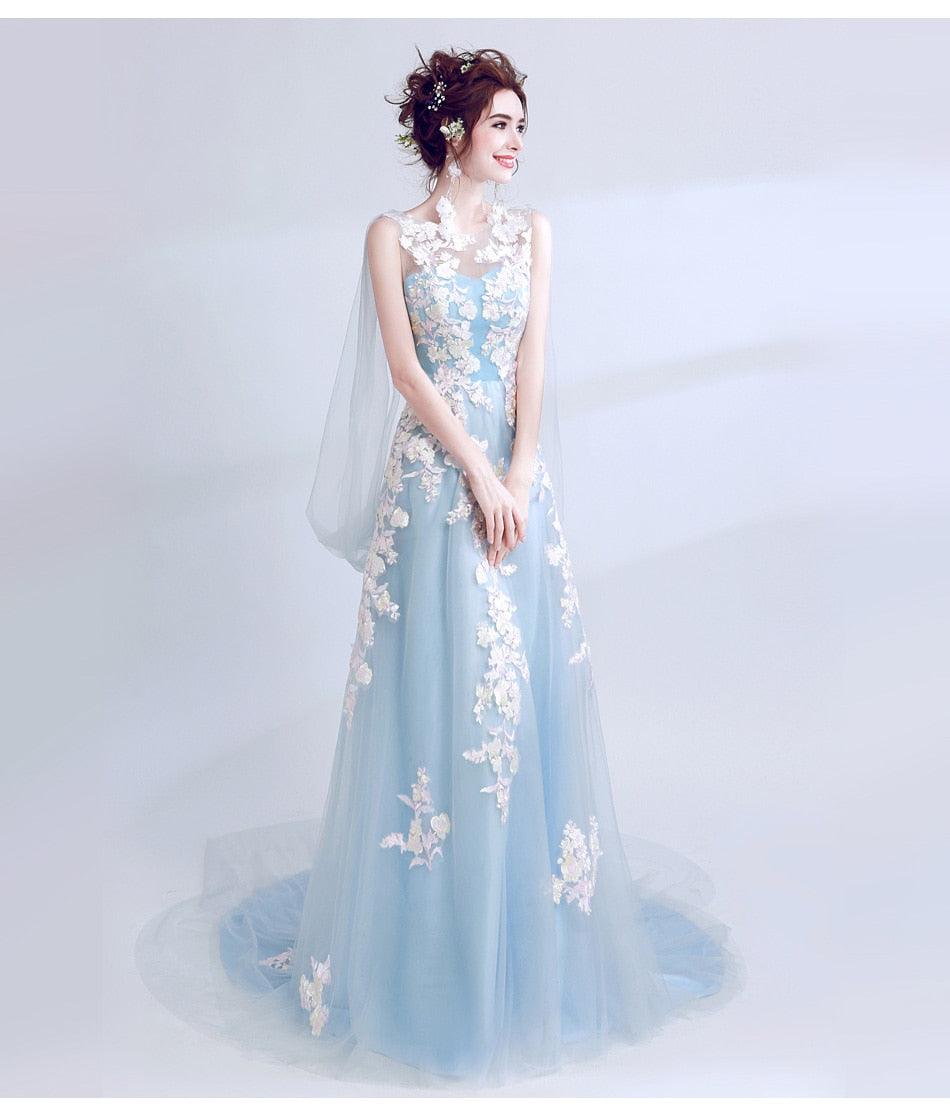 Woman wearing a light blue evening gown with floral embellishments on a white background
