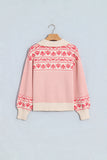 A cream-colored knit sweater with red Nordic and Fair Isle patterns, hanging on a wooden hanger against a light 