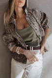 Woman wearing brown and beige animal-print shirt over olive tank top with white pants and brown belt.