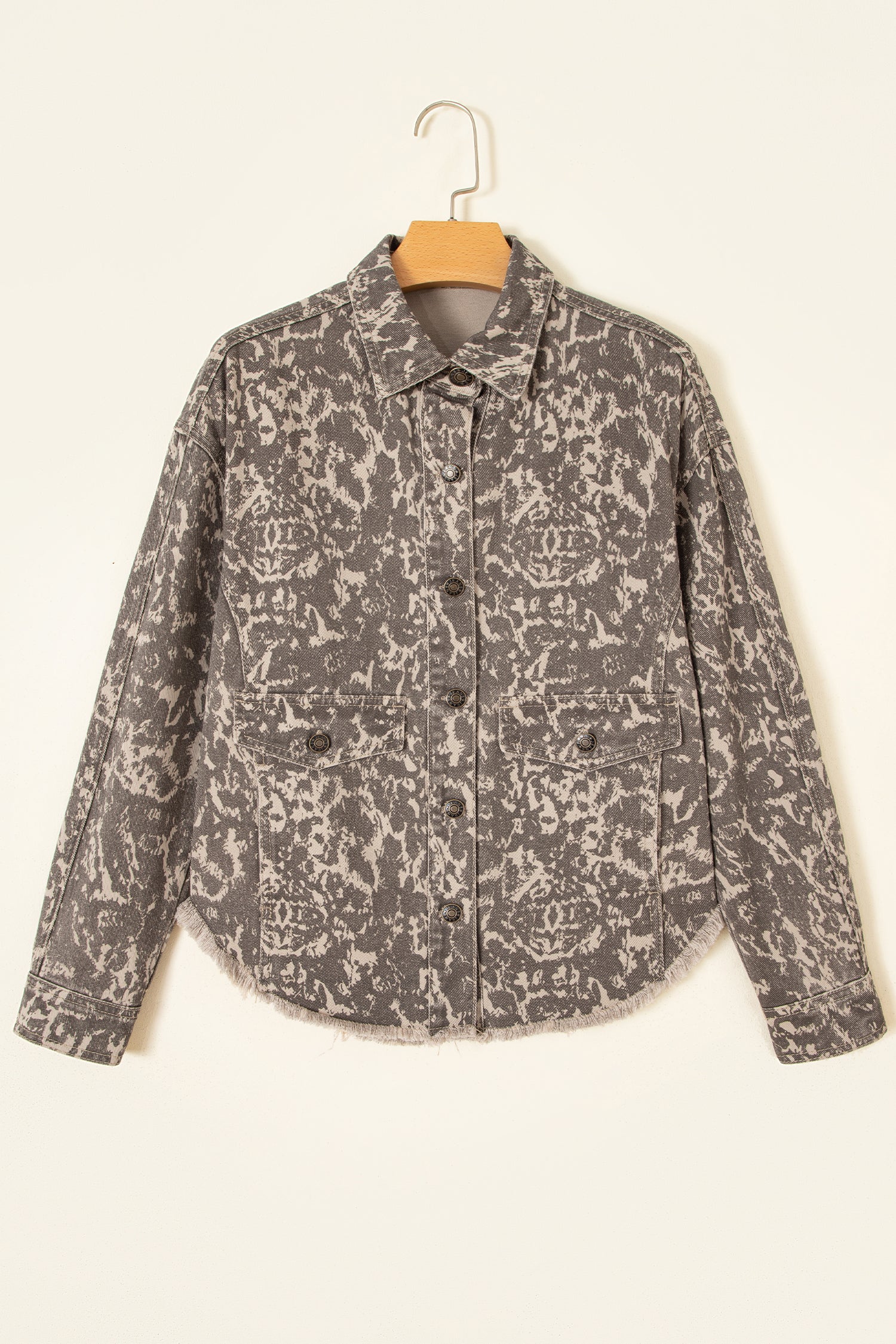 Long-sleeve button-front jacket with gray and beige abstract pattern on a wooden hanger.
