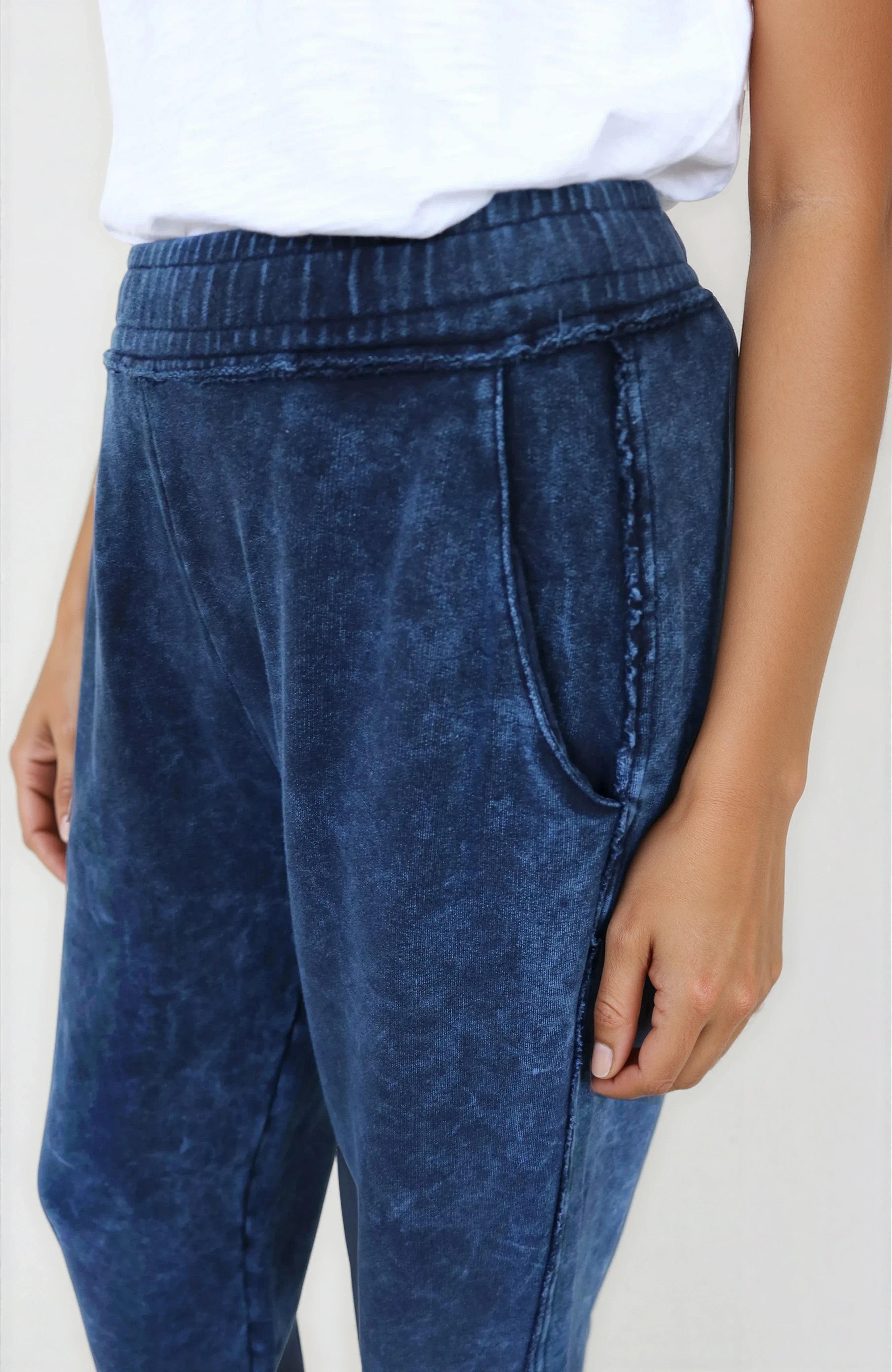 Blue acid-wash jeans worn by a person on a plain background