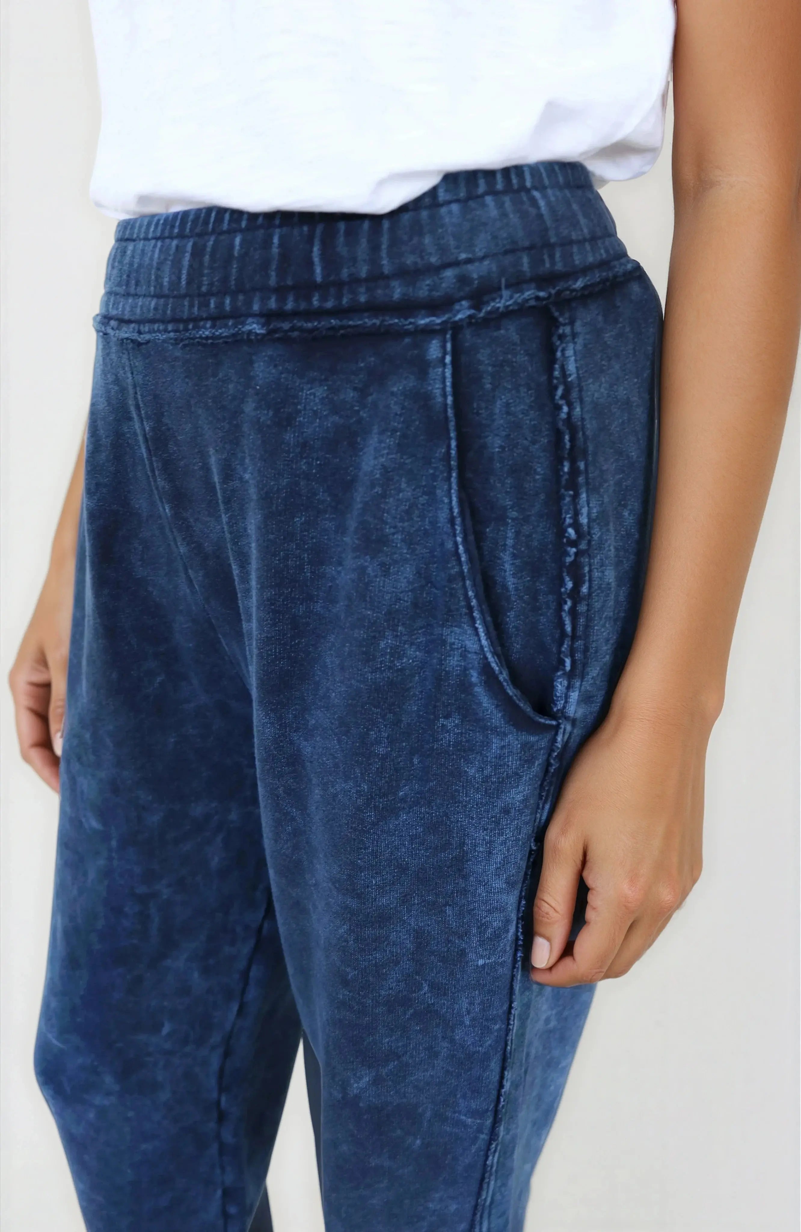 Blue acid-wash jeans worn by a person on a plain background