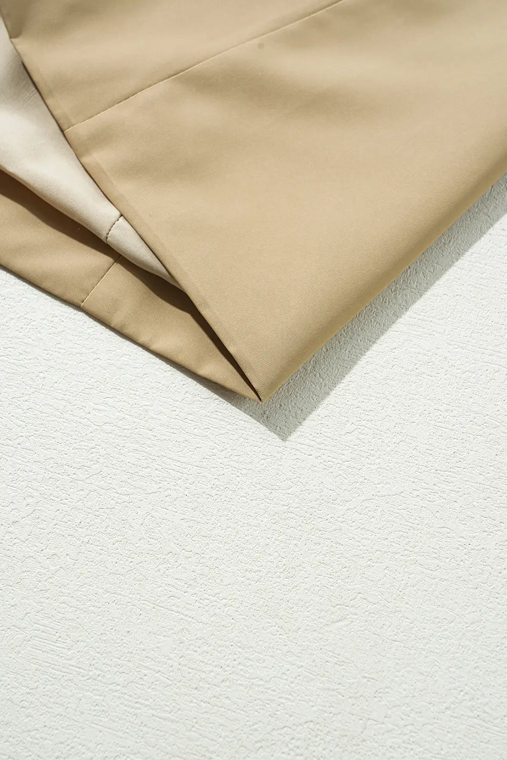 Beige fabric on a textured white surface